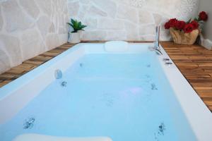a bath tub with a sink and red roses at Pharus Miseni Suites and rooms in Bacoli