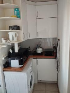 a kitchen with white cabinets and a washer at Agréable T2 climatisé, terrasse,wifi,piscine in Bandol +3 photos