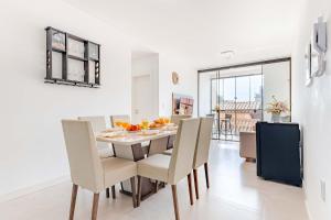 a kitchen and dining room with a table and chairs at Apartamento a 150 Metros da Praia com Piscina in Bombas