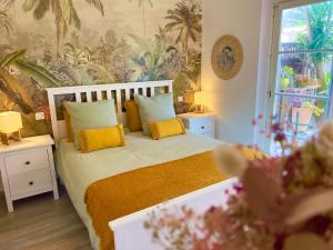a bedroom with a bed with yellow pillows at Les Cactus Fréjus Plage in Fréjus