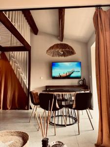 a living room with a tv and a table and chairs at Nid douillet pour vos vacances ! in Fréjus