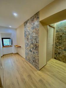 ein leeres Zimmer mit einer Steinmauer und einer Tür in der Unterkunft La Maison in Montenero Val Cocchiara