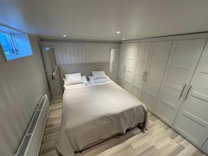 a bedroom with a bed and cabinets and a window at Fredholmsvillan kärra in Gothenburg
