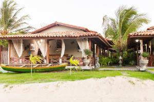 a house with a boat in front of it at Pousada Jurará e Vila Jurará in Atins +75 photos