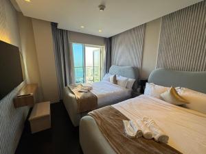 a hotel room with two beds and a window at Ultra Luxury Palm Dubai Eye Fendi 2BR Damac Height in Sabkhah