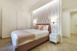 a bedroom with a large bed and a white wall at Designer Apartment in Oltrarno in Florence