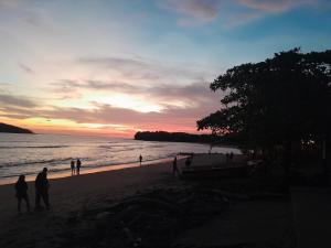 a group of people walking on the beach at sunset at Discover Coiba Panama Tour in Santa Catalina +26 photos