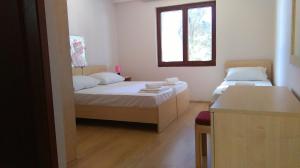 a small room with two beds and a window at Resort Village T.N. Milna in Vis