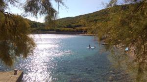 two people in a paddle boat on a lake at Resort Village T.N. Milna in Vis