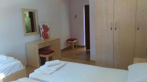 a bedroom with a bed and a desk and a mirror at Resort Village T.N. Milna in Vis