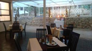 a restaurant with tables and chairs and a stone wall at Resort Village T.N. Milna in Vis +19 photos