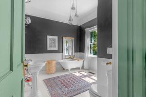 a bathroom with a white tub and a sink at Wine Country Retreat with Pool & Hot Tub - Dogs OK in Guerneville