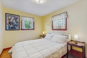 a bedroom with a large bed and two windows at Southern Comfort in Tazewell
