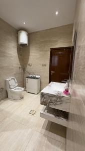 a bathroom with a toilet and a sink and a tub at Madain Al Baraka Suites أجنحة مدائن البركة in Medina