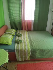 a bedroom with a bed with two pillows and a window at Guesthouse Panorama in Mostar