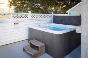 a hot tub with a bench and a chair next to it at Private Pool Spa & Spacious Deck in Corolla