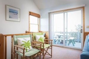a living room with two chairs and a balcony at Private Pool Spa & Spacious Deck in Corolla +46 photos