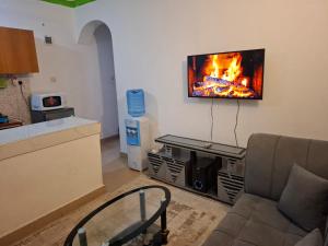 モンバサにあるAisha Luxury Apartmentsのリビングルーム(ソファ、壁掛けテレビ付)