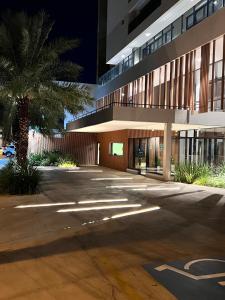 a building with a palm tree in front of it at ID Vida Urbana Studio Floresta in Goiânia