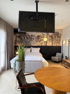 a bedroom with a large bed and a table at ID Vida Urbana Studio Floresta in Goiânia +13 photos