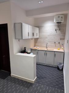 a small kitchen with white cabinets and a sink at Madain Al Baraka Suites أجنحة مدائن البركة in Medina