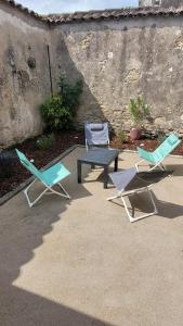 three lounge chairs and a table and a bench at Maison élégante entre Ré et Marais in Marans