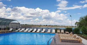 a pool with chaise lounge chairs and a swimming pool at Boat Station in Kapchagay