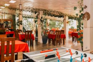 a restaurant with red tables and chairs and a pool table at 5 Swiss Hotel in Kigali