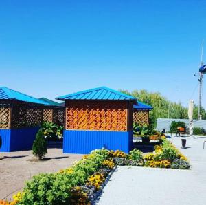 a building with a garden with flowers in front of it at Boat Station in Kapchagay +9 photos