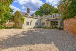 ein großes weißes Haus mit Ziegelwand in der Unterkunft Honeypot cottage in Lower Assendon