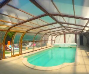an indoor swimming pool with a glass ceiling at Écolodge Les Sentiers du Lac - Domaine de la Gaïa in Sorèze