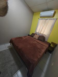 a small bedroom with a bed with a window at Hostal La Campana in San Miguel