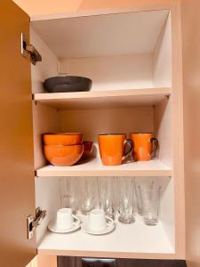 an open cabinet with cups and glasses in it at Garden villa two-bedroom suite in Vari