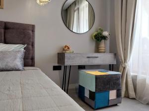 1 dormitorio con cama y mesa con espejo en Ika Apartment Central, en Burgas