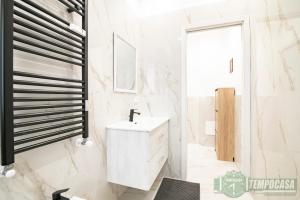 a white bathroom with a sink and a mirror at Regina in Sesto San Giovanni +19 photos