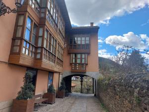 a large building with a stone wall and a tunnel at Céntrico apartamento en el casco antiguo de Potes in Potes