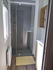 a shower with a glass door in a bathroom at KOKUA VACANCES Mobil Homes Résidentiels camping 4 étoiles JULIEN EN BORN in Saint-Julien-en-Born