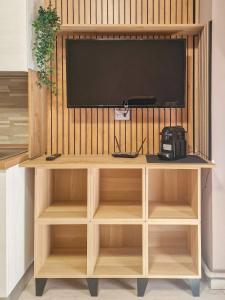 a television on top of a wooden entertainment center at Nido nel verde in Segrate