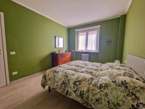 a bedroom with green walls and a bed and a window at Nido nel verde in Segrate