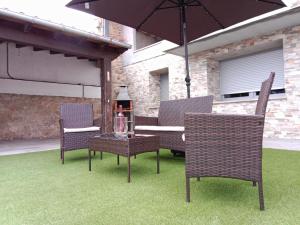 a patio with a table and chairs and an umbrella at Abril 56 Villa&Suites in Oreña