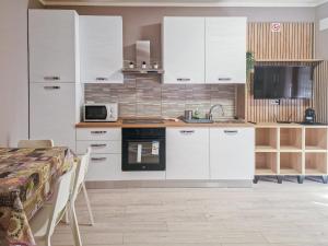 a kitchen with white cabinets and a table and a microwave at Nido nel verde in Segrate