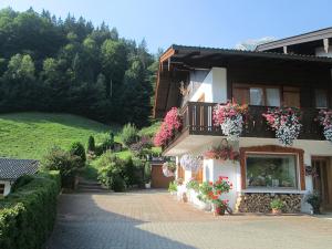 a house with flowers on the side of it at Haus Öfenbichl Ferienwohnungen in Ramsau