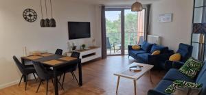 un soggiorno con un divano blu e un tavolo di Pinea Seaside Apartament Pobierowo a Pobierowo