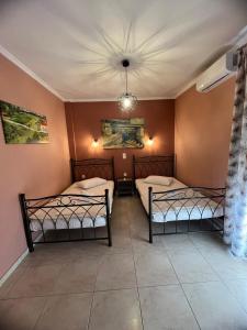 two beds in a room with a ceiling at Casa Loutsiano in Syvota