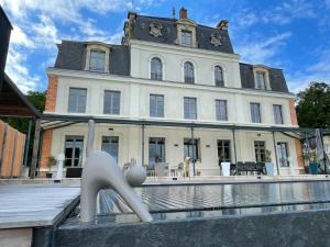 un edificio con una fontana di fronte a una casa di Chateau aux portes du circuit des 24h a Yvré-lʼÉvêque