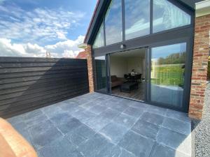 a patio with sliding glass doors on a house at Boszicht aan Zee, new holiday home in Biggekerke in Biggekerke +8 photos