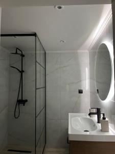 a bathroom with a sink and a shower with a mirror at Lohias House in Lefkada Town