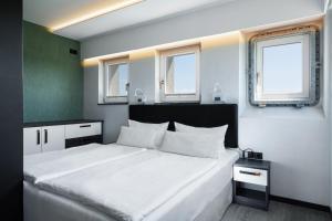 a bedroom with a large white bed with two windows at Panoramasuite The Turm - Penthouse in Wustrow