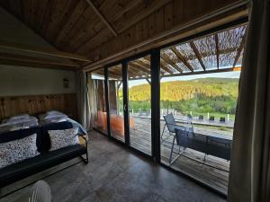 a bedroom with a bed and a balcony with a view at Stodoły w Bieszczadzie domy SPA z basenem i widokiem na góry in Polańczyk