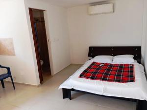 a bedroom with a bed with a plaid blanket on it at Habitaciones frente al mar in Carretal